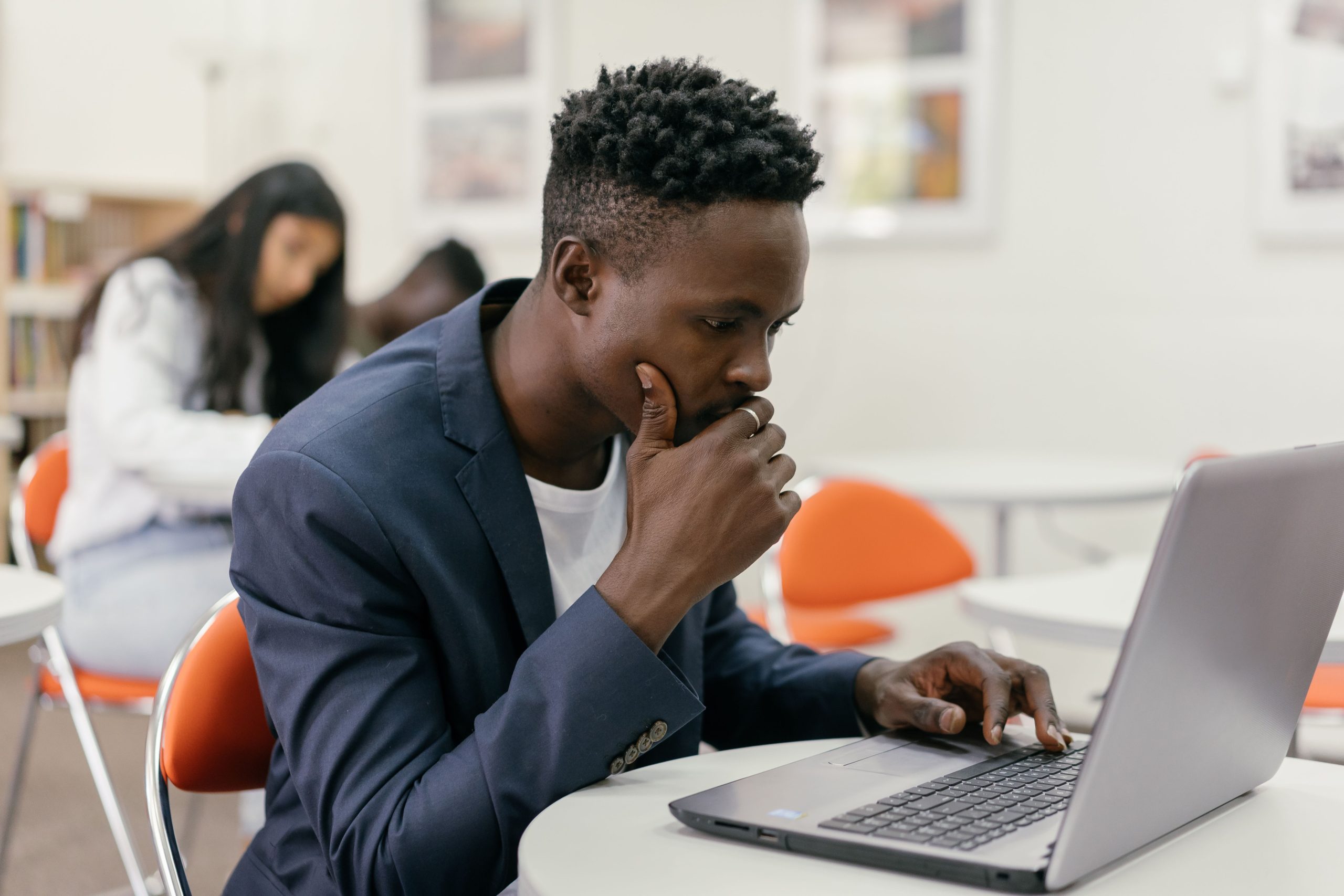 Étudiant concentré travaillant sur laptop en classe moderne