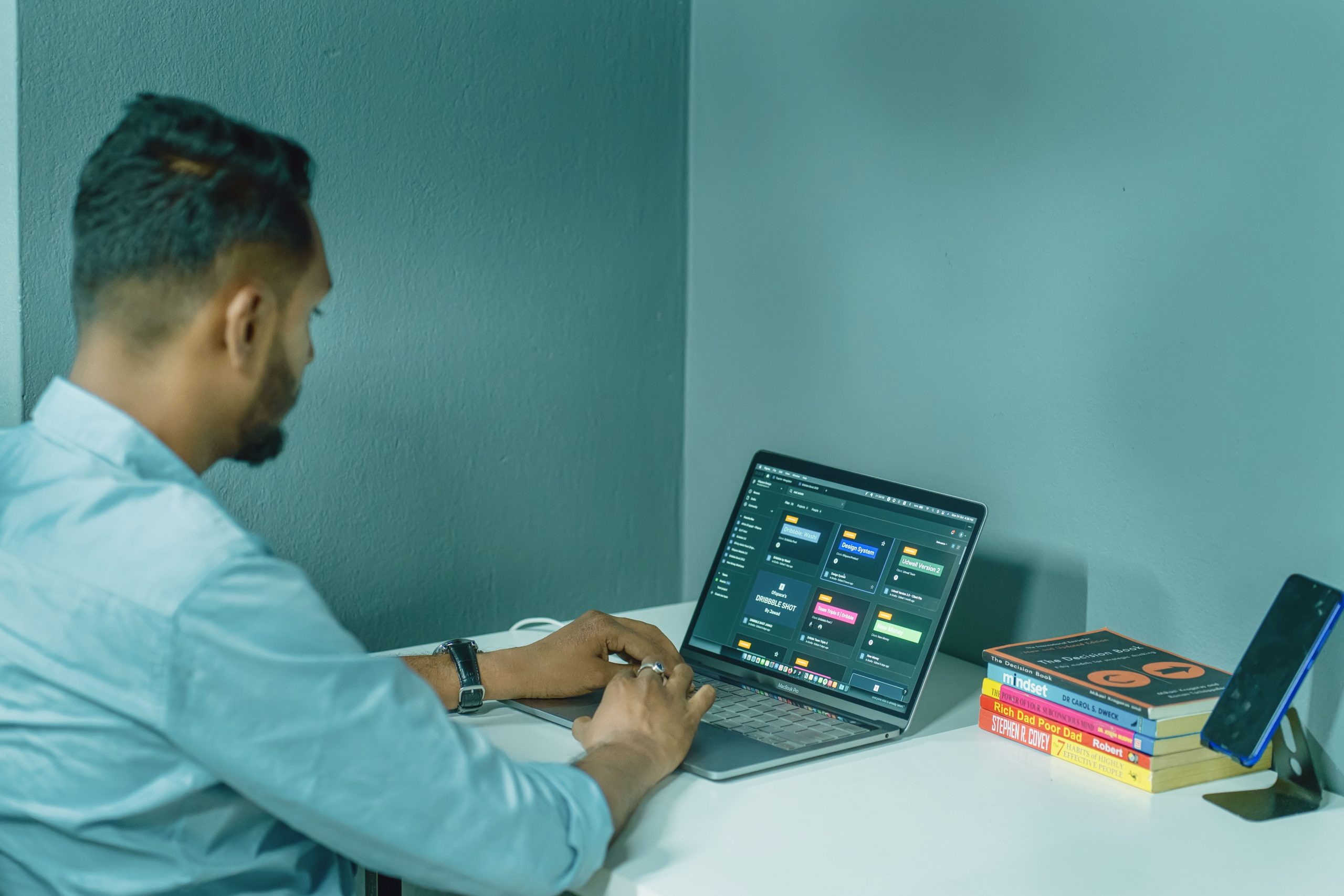 Homme travaillant à son bureau entouré de livres