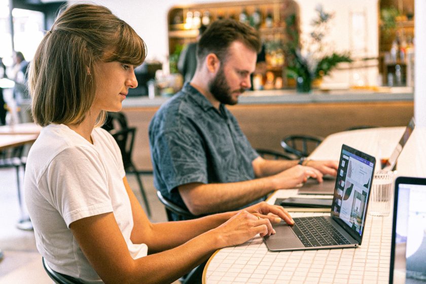 Deux professionnels travaillant sur ordinateur en cafe