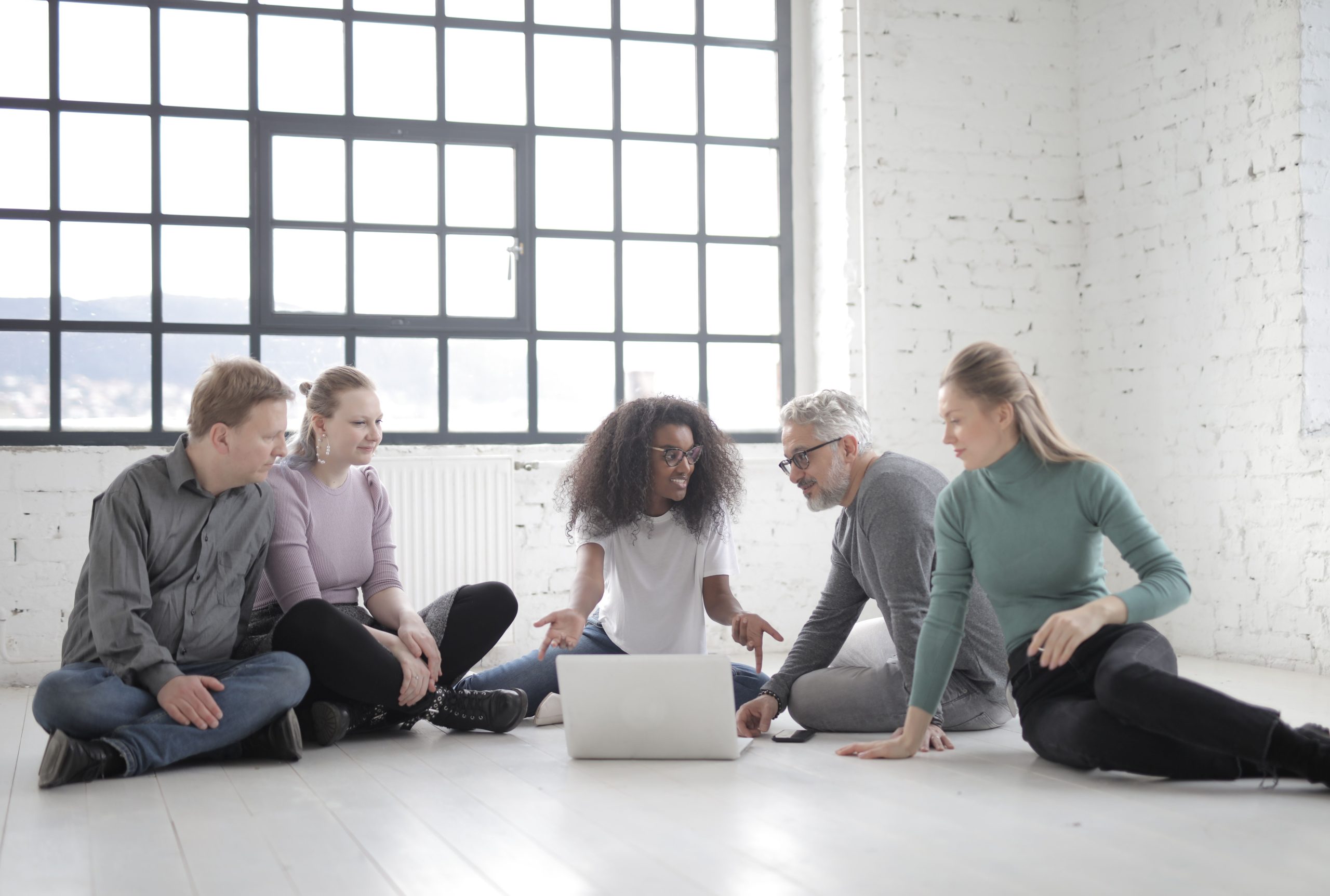 Groupe multiculturel discutant idées avec ordinateur portable