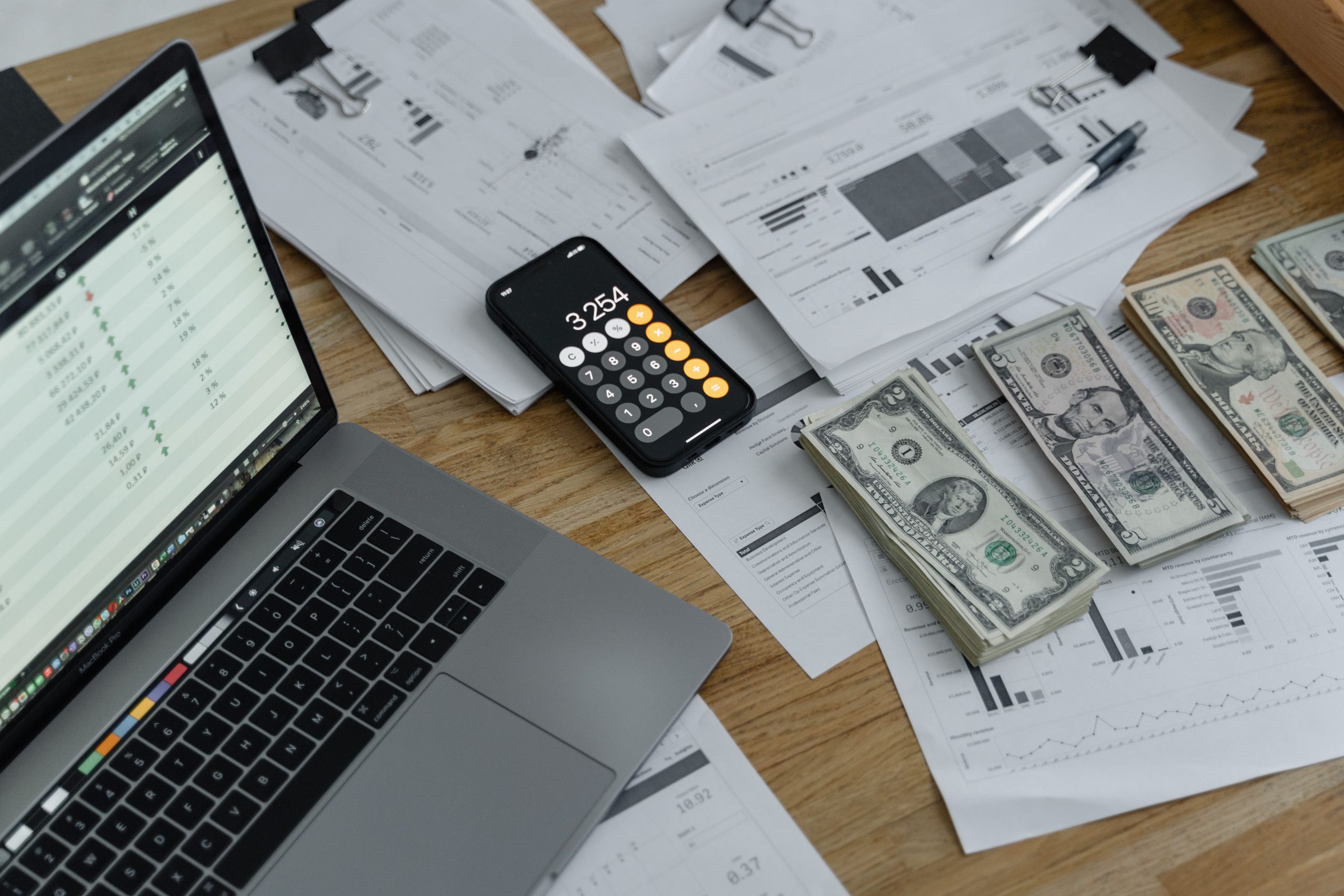 Bureau avec documents financiers, billets et calculatrice