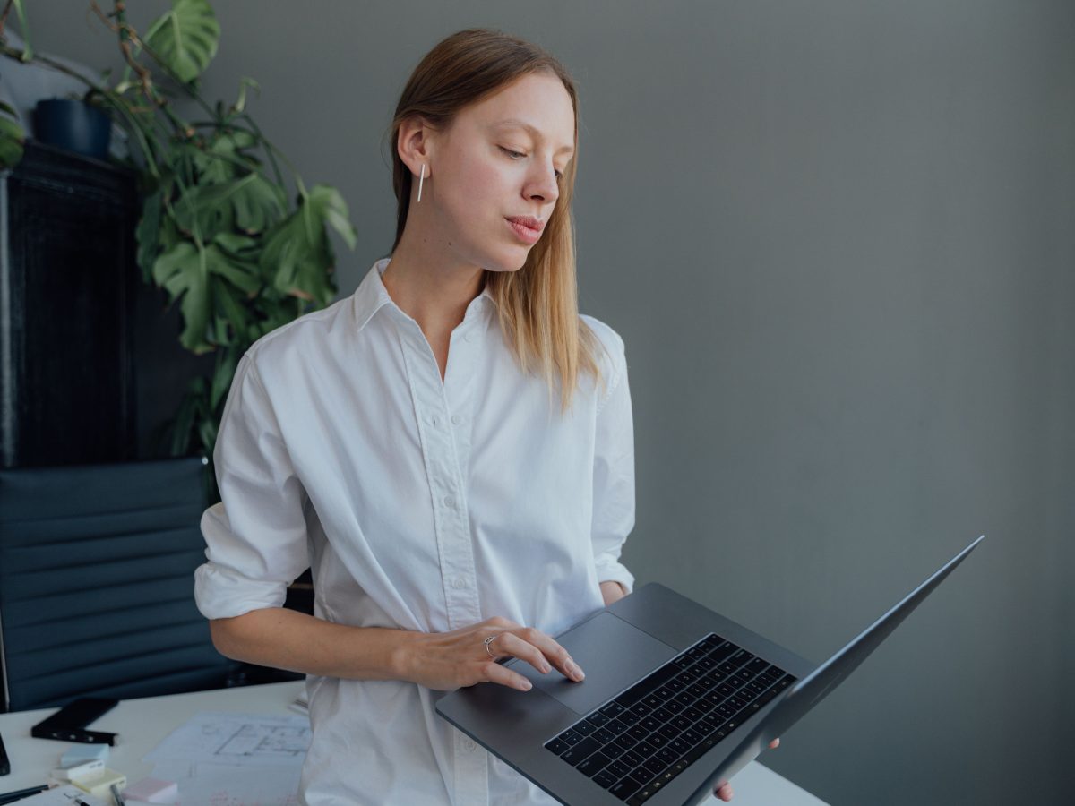 Femme travaillant sur laptop en bureau moderne.