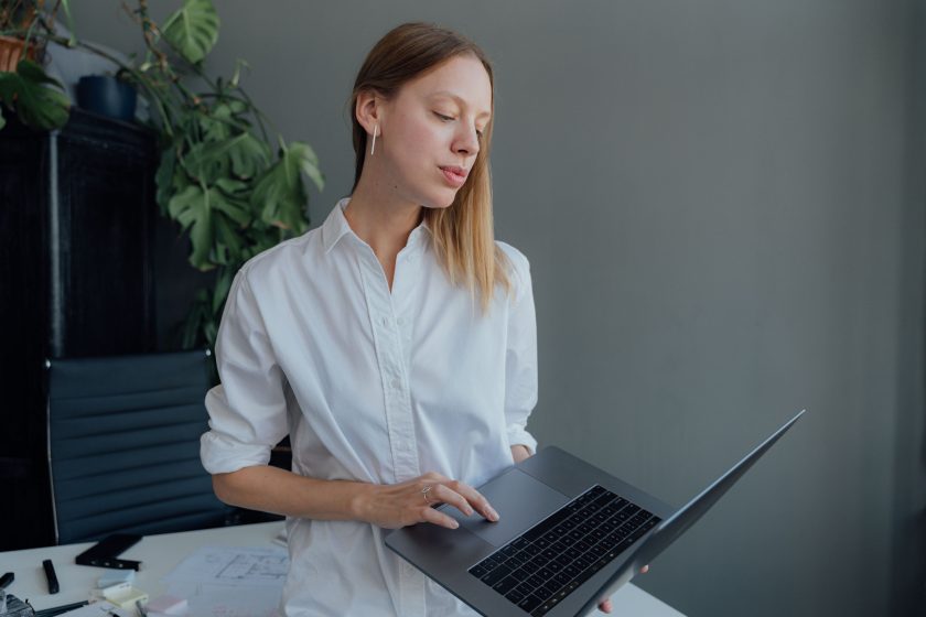 Femme travaillant sur laptop en bureau moderne.