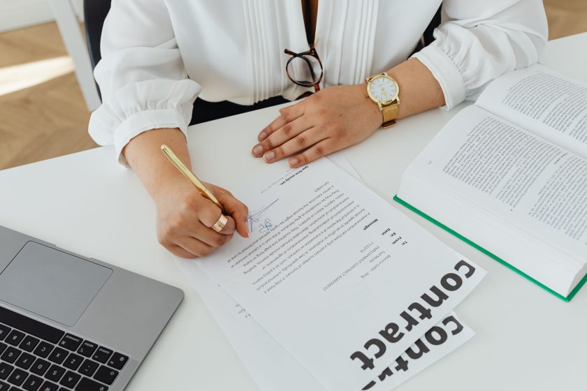 Femme d'affaires signant un contrat à son bureau
