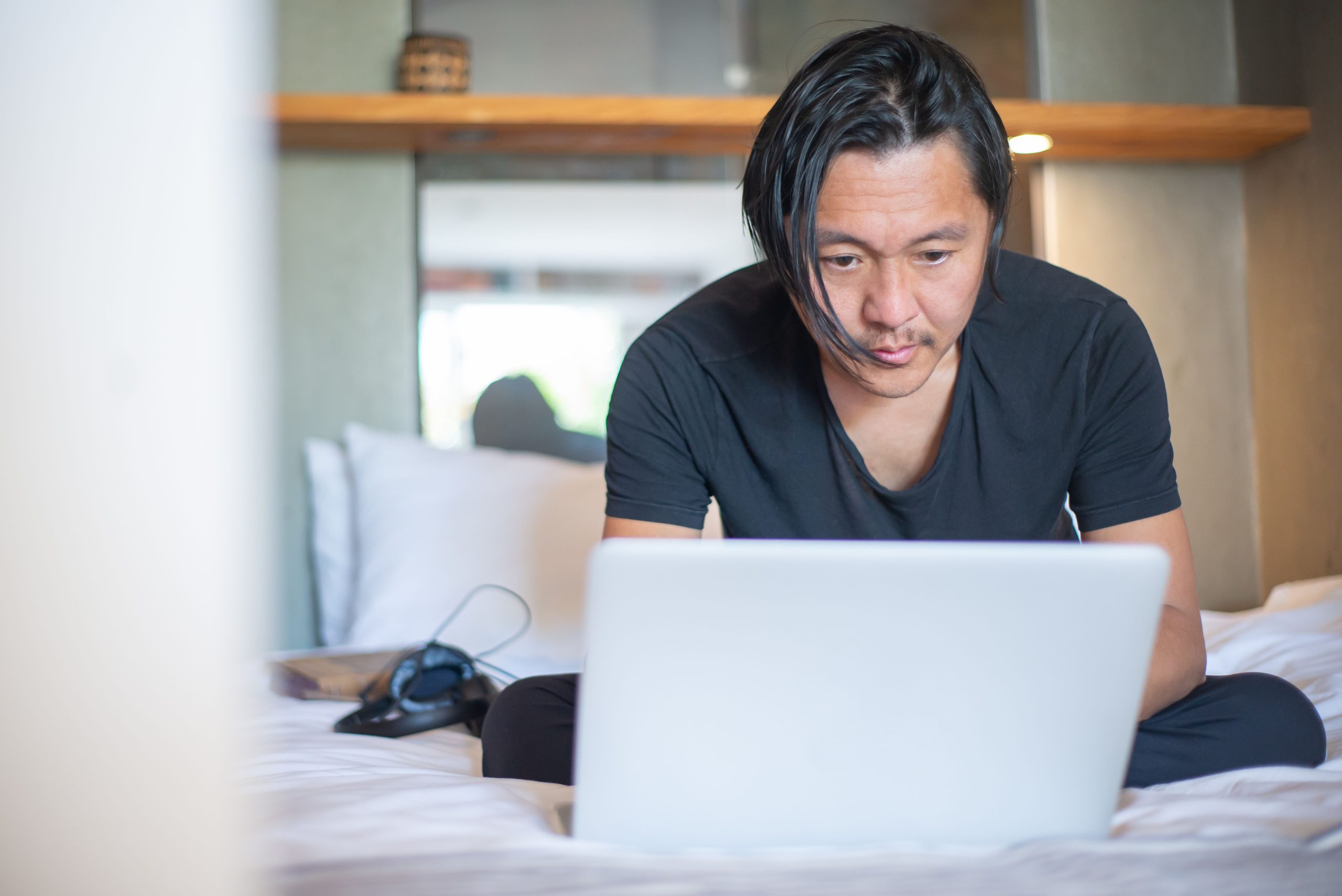 Homme asiatique travaillant sur laptop à domicile