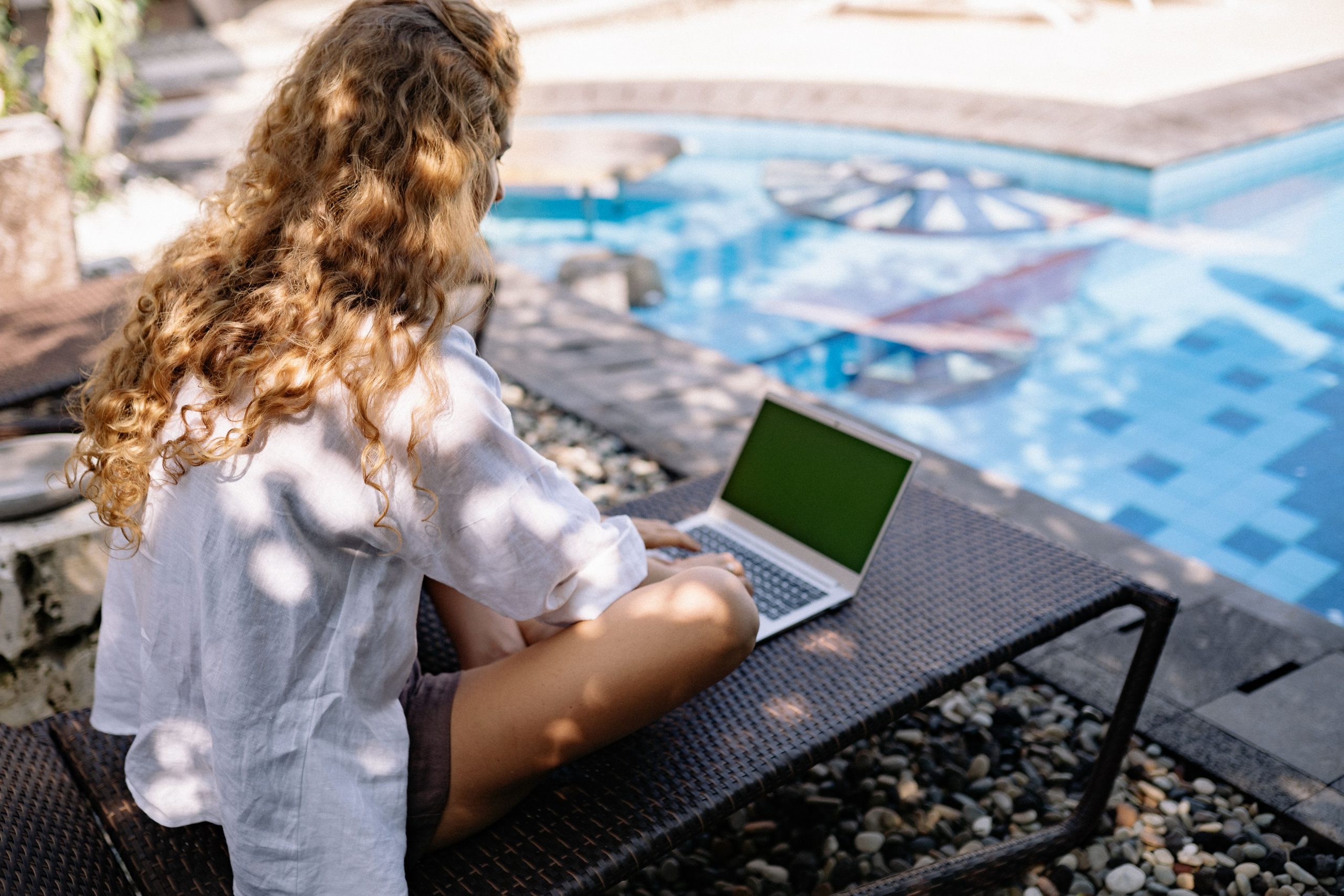 Femme nomade digitale travaillant près piscine