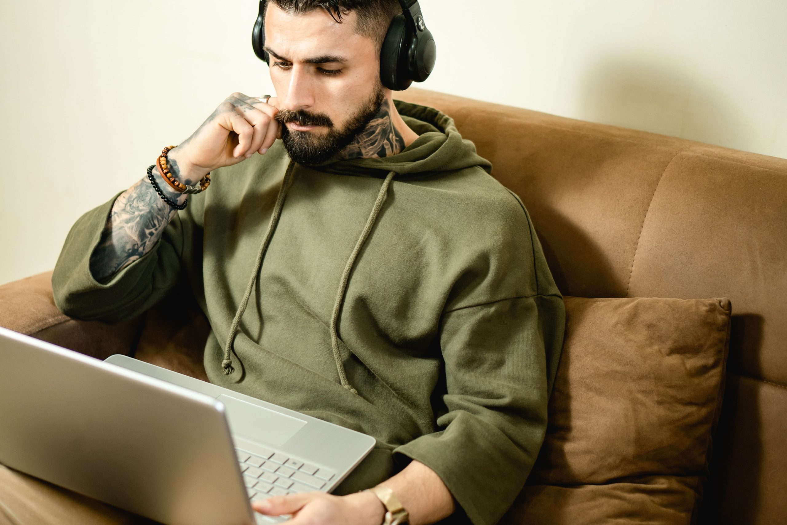Homme tatoué avec casque travaillant en remote