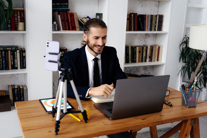 Homme en costume souriant pendant un appel vidéo professionnel
